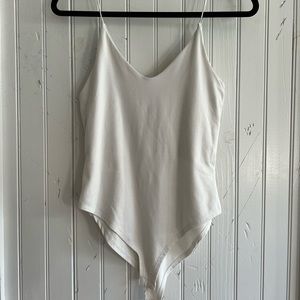 White bodysuit with snaps at the bottom.